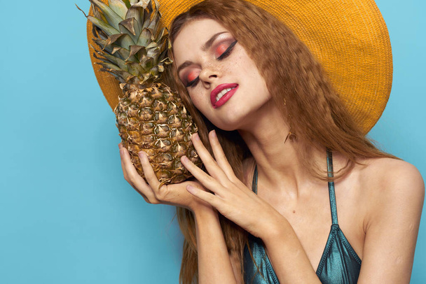 woman in beach hat pineapple holding swimsuit exotic fruits blue background vacation - Foto, Imagen
