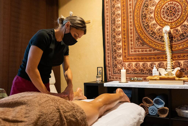Massaggiatrice che fa un massaggio alle gambe a un cliente - Foto, immagini