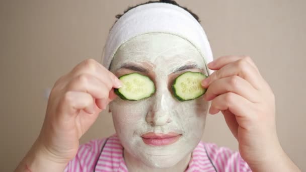 Fiatal nő maszk az arcon játszik uborka gyűrűk, csukott szemmel - Felvétel, videó
