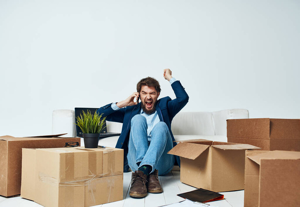 Uomo in una tuta scatole con le cose in movimento ufficio professionale disimballaggio - Foto, immagini