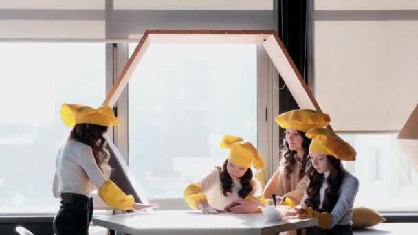 Crianças em chapéus amarelos ajudam a cozinhar pizza na cozinha. - Filmagem, Vídeo