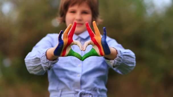 Les mains des enfants peintes en couleur drapeau des Seychelles montrent le symbole du cœur et du geste d'amour. Enfant jouer peinture mains - Séquence, vidéo
