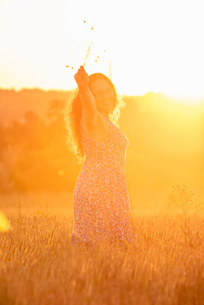 hermosa mujer madura en vestido de sol en el campo de trigo en el espacio de copia puesta del sol - Foto, imagen