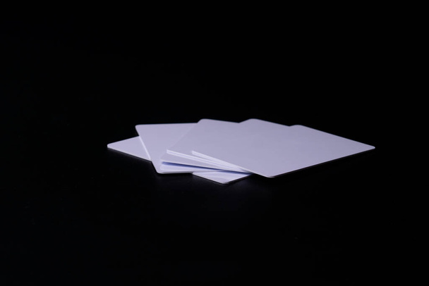 Pilha de Proximidade ou cartão RFID tipo branco fino, flexível, sobre fundo preto. Cinco cartas. - Foto, Imagem