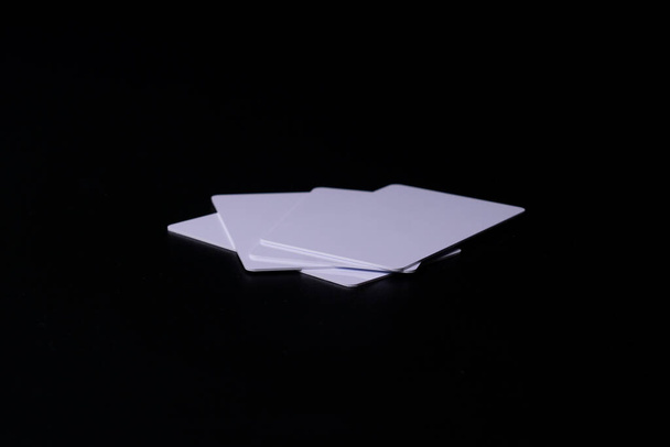 Pila di prossimità o carta RFID tipo bianco sottile, flessibile, su sfondo nero. Quattro carte. - Foto, immagini