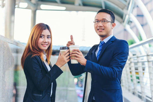Businessman Businesswoman drink coffee in town outside office modern city. Hands holding take away coffee cup talking together happy fun. Partner Business people formal suit with cup of coffee - Photo, Image