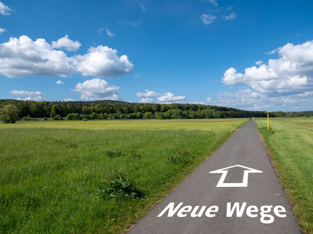 Camino con texto y flecha "Nuevos caminos" en alemán - Foto, imagen
