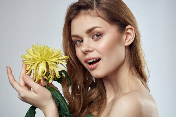 όμορφη γυναίκα λουλούδια γυμνοί ώμοι καλλυντικά γοητεία δώρο - Φωτογραφία, εικόνα