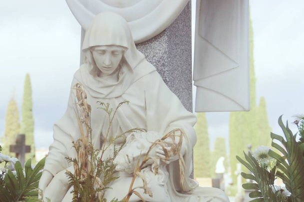 スペインのマドリードにあるカトリック墓地の墓にある近代的な彫像。愛する人の喪失の痛みを反映した装飾的な彫刻. - 写真・画像