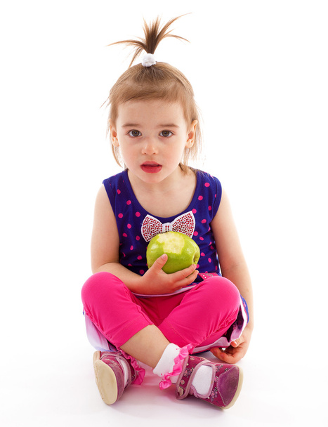 little girl with apple. - Фото, изображение