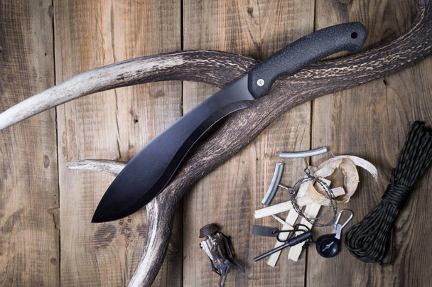 Μαύρη μαχαίρα για να κόβεις ξύλα. Μαύρα φακελάκια για γεωργικές εργασίες. - Φωτογραφία, εικόνα