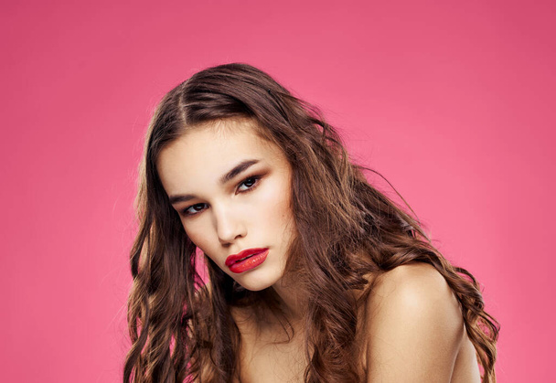 Pink background female portrait bared shoulders red lips - Photo, image