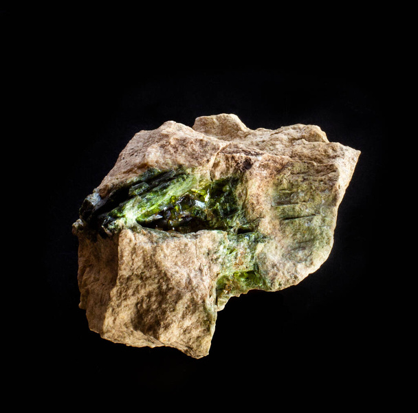 Blotting of green actinolite mineral crystals in rock from Ural, Russia. Uma foto de fundo de uma pedra isolada em preto. Sites de geologia, catálogo de coleção de pedras, gráfico de parede do museu de ciências naturais. - Foto, Imagem