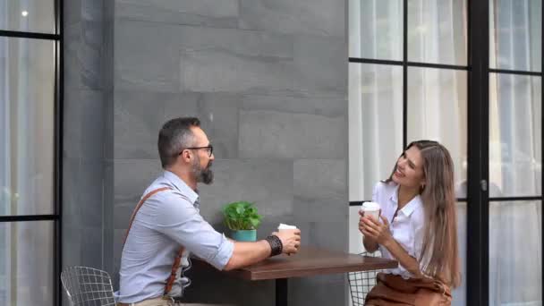 Verliebte Paare trinken Kaffee und amüsieren sich im Café. Junge Geschäftsleute draußen. - Filmmaterial, Video