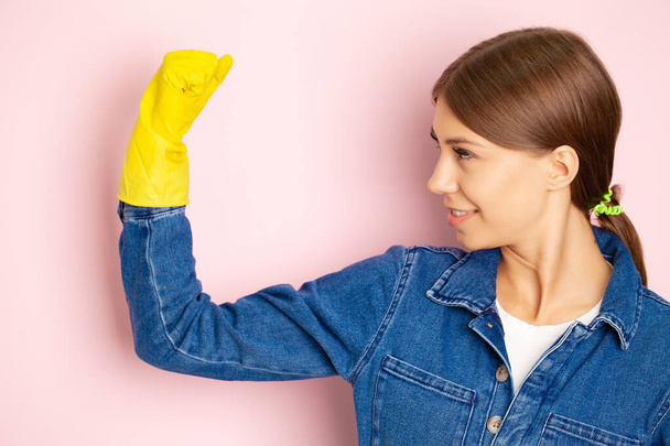 Temizlik şirketi çalışanı, sarı eldivenler ve temizlik malzemeleri. - Fotoğraf, Görsel