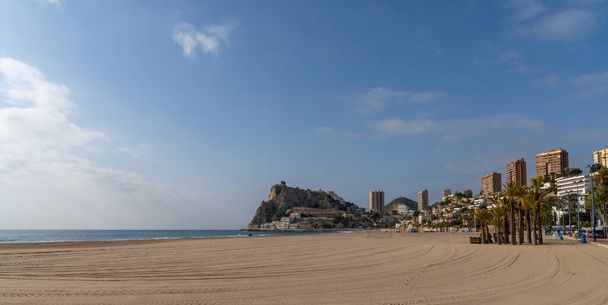 Blick auf den leeren Strand von La Cala und Benidorm mit seinen Hotels und Hochhaus-Skyline dahinter - Foto, Bild