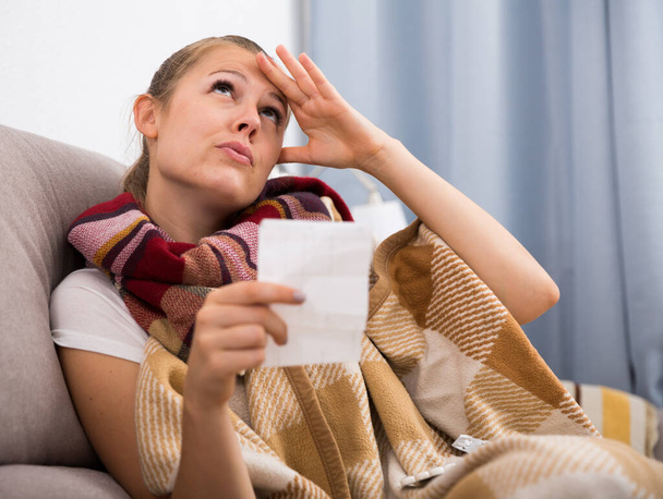 Sick woman lying with plaid and reading recipe - Foto, Imagem