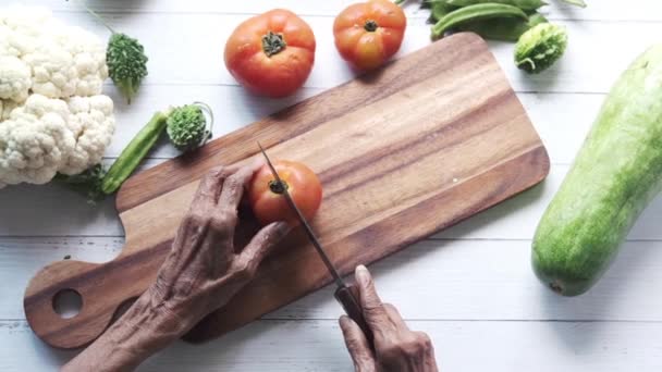 Mujeres mayores cortando tomates en la tabla de cortar  - Imágenes, Vídeo