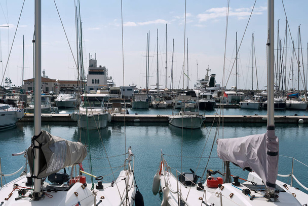 Soluk mavi gökyüzünün önünde demirli beyaz tekneleri ve metal direkli yatları olan deniz marinası, Limasol, Kıbrıs - Fotoğraf, Görsel