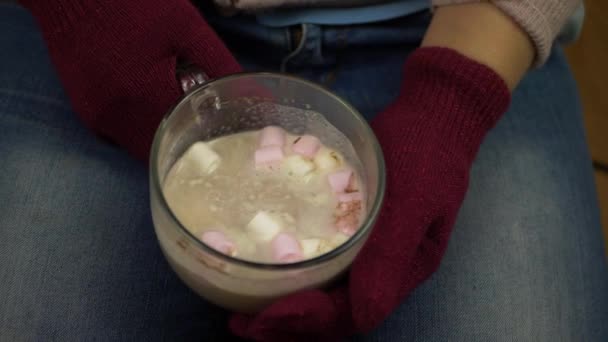 Nainen nauttii muki kuumaa kaakaota vaahtokarkkeja - Materiaali, video