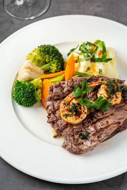 Lahodný šťavnatý grilovaný steak a krevety s grilovanou brokolicí a květákem. Surf and Turf style.  - Fotografie, Obrázek