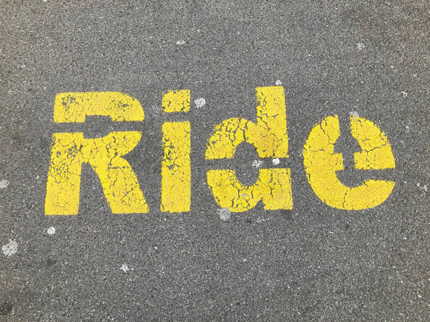 Yellow Ride inscriptie geschilderd op asfalt bij de drop off parkeerplaats in Zug, Zwitserland - Foto, afbeelding