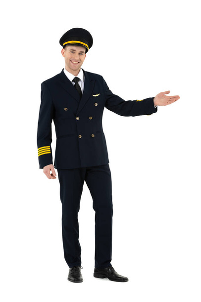 Przyjazny i uroczy pilot linii lotniczych stojących i witających ludzi na pokładzie odizolowanych na białym tle - Zdjęcie, obraz