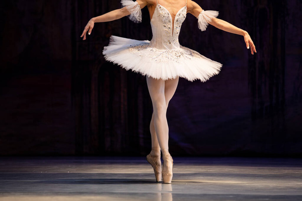 Closeup of ballerina dancing isolated on stage. Ballerina legs closeup - Photo, Image