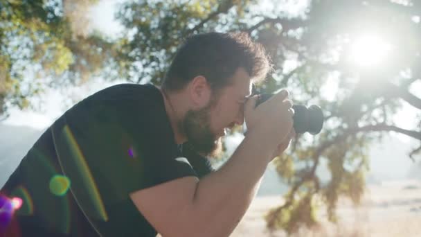 Zeitlupe fokussierter Fotograf, der in ein professionelles Kamerafenster schaut, um Fotos zu machen - Filmmaterial, Video