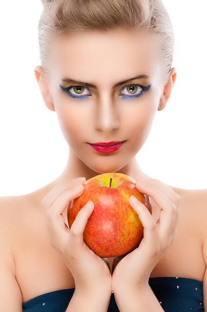 Fiatal, imádnivaló, mosolygós nő, meztelen vállakkal és fényes sminkkel egy nagy vörös almát tart a kezében. Fehér alapon elszigetelve. - Fotó, kép
