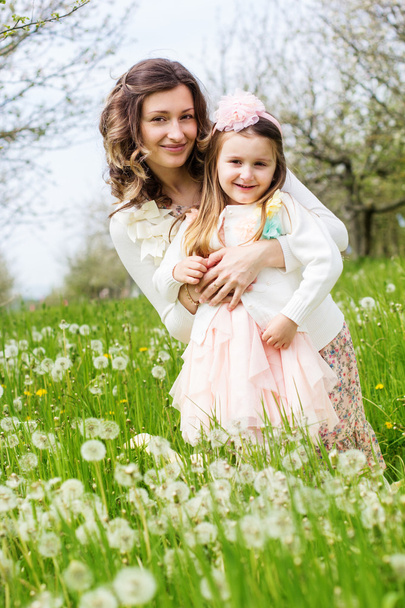 Mother and daughter in field with dandelions - Foto, Bild