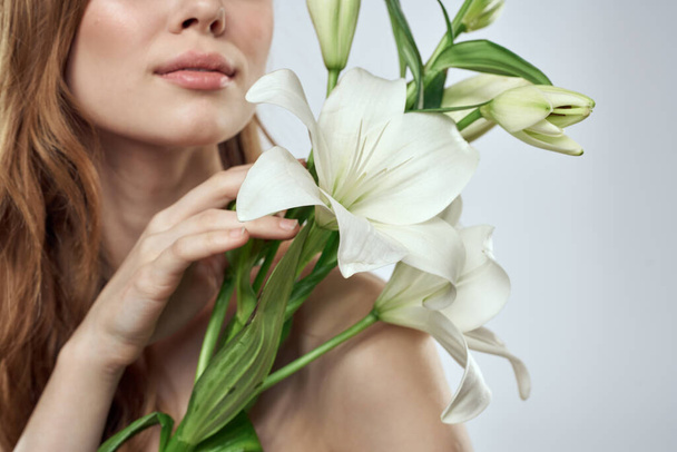 Portrait of a beautiful woman with white flowers on a light background - Photo, Image