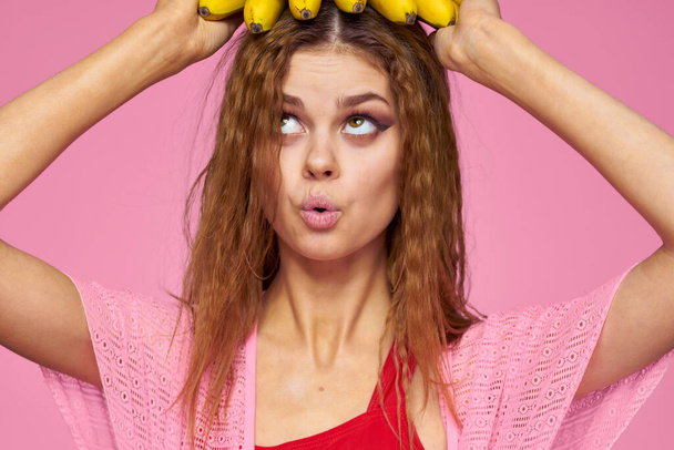 Kobieta z bananami faliste włosy owoce styl życia jasny makijaż różowy tło - Zdjęcie, obraz