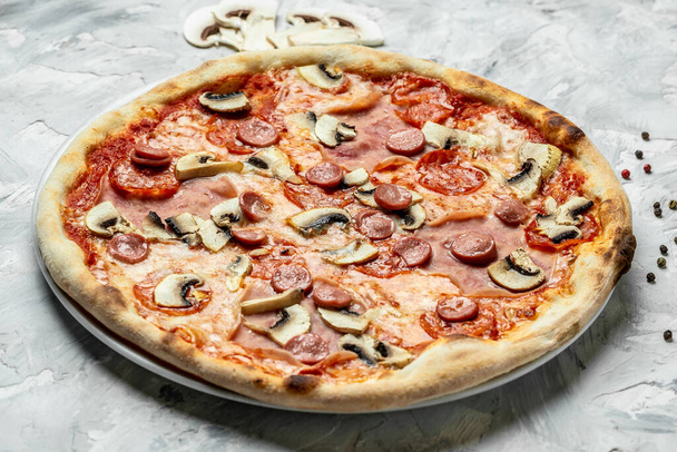 Pizza italiana capriciosa pomodoro fungo e mozzarella. cottura in forno nel ristorante tradizionale. - Foto, immagini