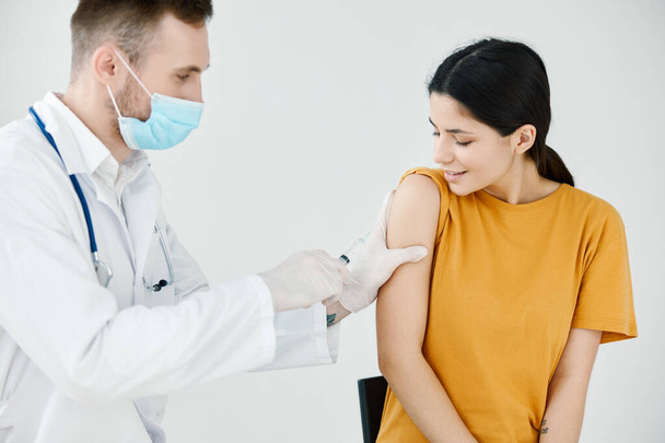 врач записывает инъекцию на плечевую ковидовую вакцинацию пациентов - Фото, изображение