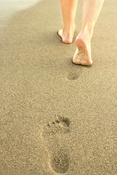 Mädchen hinterlässt Fußabdrücke im Sand - Foto, Bild