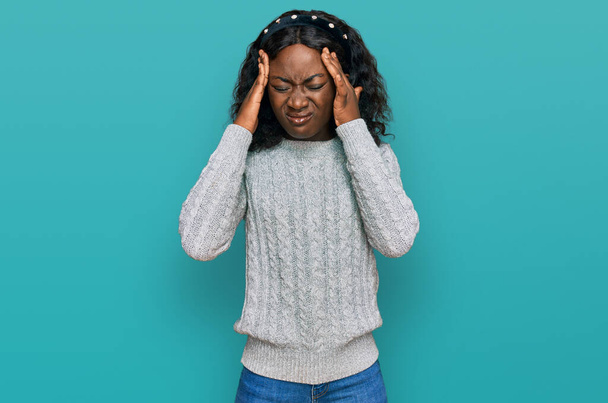Beautiful african young woman wearing casual winter sweater with hand on head for pain in head because stress. suffering migraine.  - Photo, Image