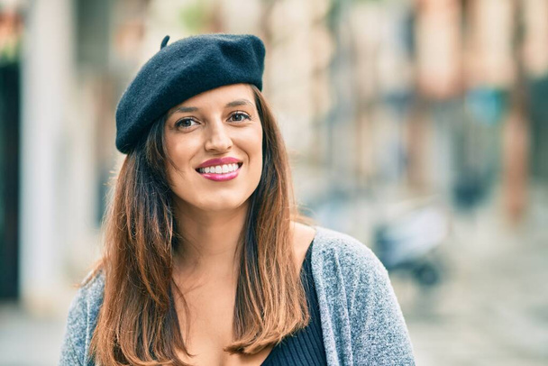 Jovem mulher latina vestindo estilo francês em pé na cidade. - Foto, Imagem