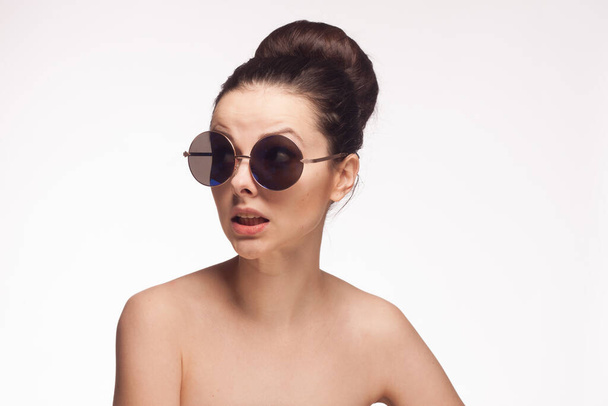 pretty brunette naked shoulders sunglasses clear skin light background - Photo, Image