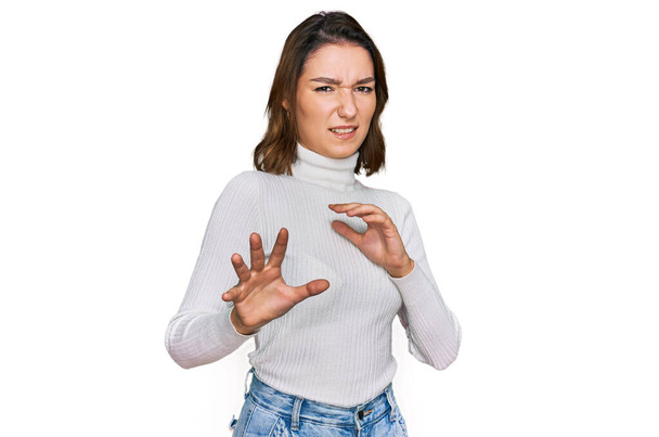Junge kaukasische Mädchen in lässiger Kleidung angewidert Ausdruck, unzufrieden und ängstlich tun Ekel Gesicht, weil Abneigung Reaktion. mit erhobenen Händen  - Foto, Bild