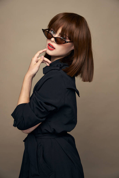 Charming brunette touches her face with her hand and looks ahead black coat Copy spaces - Fotó, kép