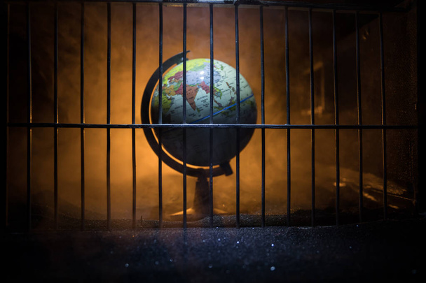 Corona virus lockdown creative concept. Planet earth trapped inside old prison. Creative artwork decoration. Selective focus - Photo, Image