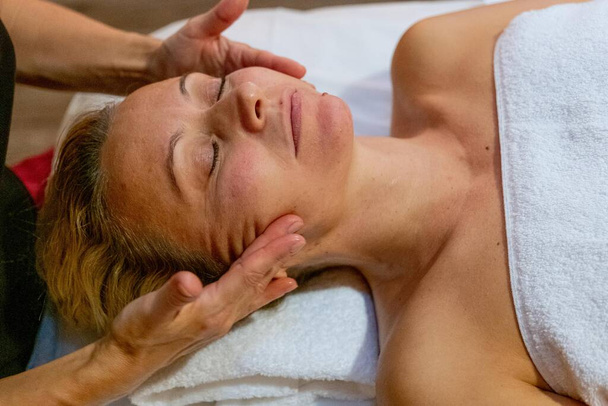 Masseuse donnant un massage facial à un client avec thérapie du bois - Photo, image