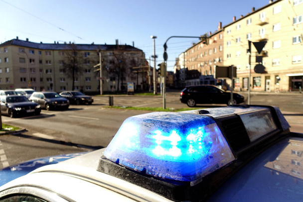 Feux clignotants bleus sur une voiture de police dans une ville en Allemagne. Maisons, voitures et rues en arrière-plan. - Photo, image