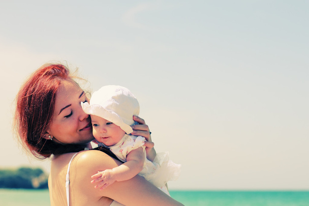 Retrato de madre feliz y su bebé en la playa
 - Foto, Imagen