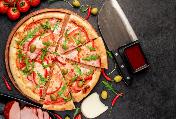pizza with ingredients on black table surface - Photo, Image