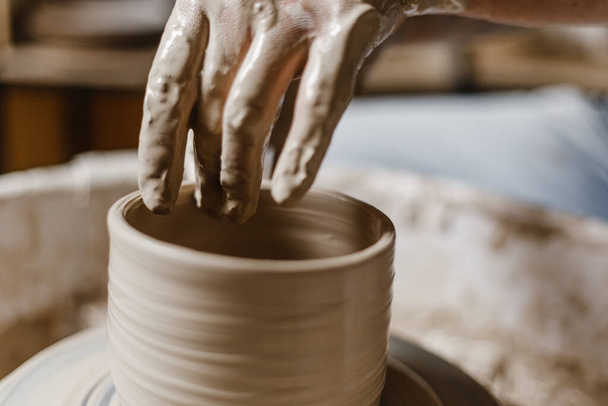 Vrouwelijke handen maken borden van klei - Foto, afbeelding