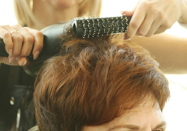 mano peluquero con tijeras haciendo corte de pelo y tinte de pelo en el primer plano del cliente foto - Foto, imagen