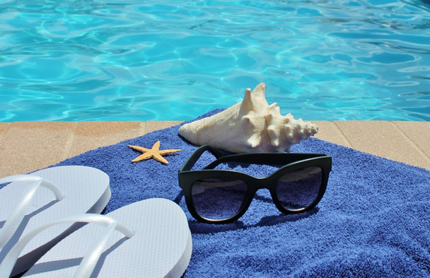 Vacaciones junto a la piscina pintoresca piscina gafas de sol de verano toalla de concha
 - Foto, Imagen