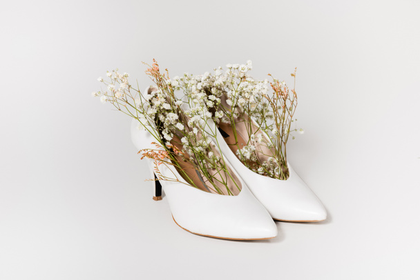 heeled shoes with tiny gypsophila flowers on white  - Zdjęcie, obraz